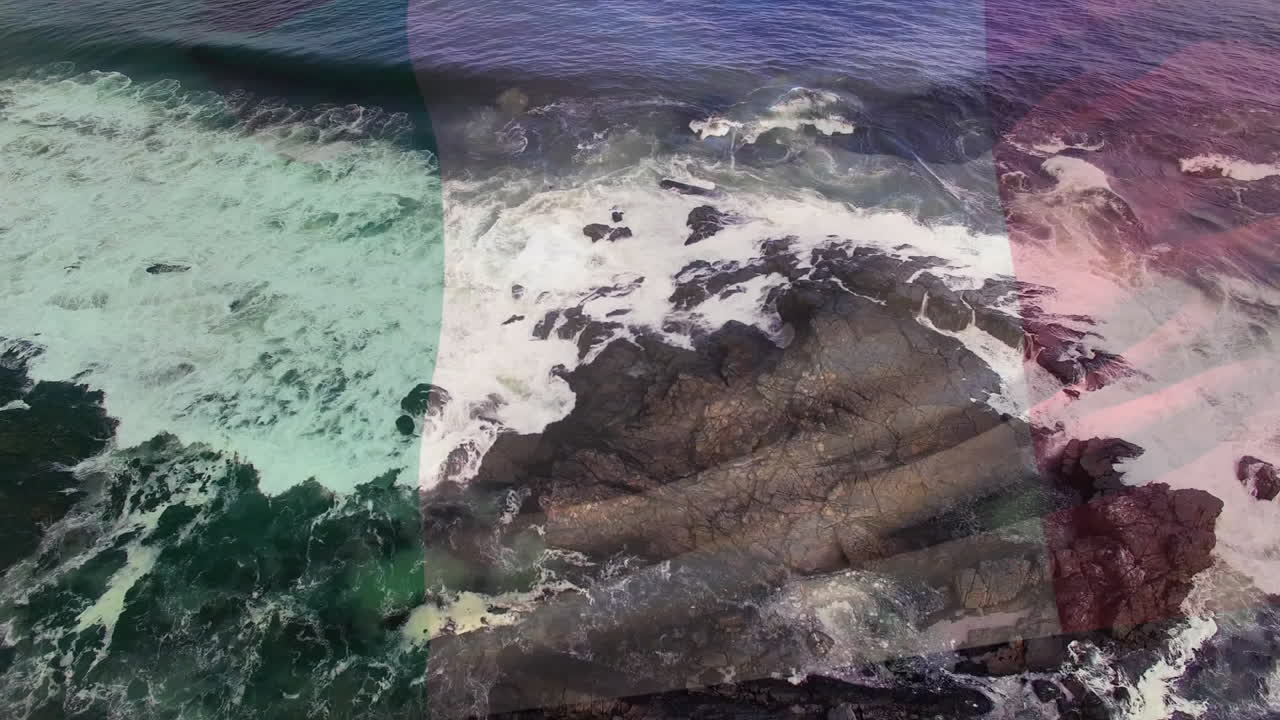 composición digital de ondear la bandera de italia contra las olas del mar que golpean las rocas