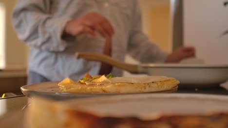 close up omelet put on plate by pregnant woman preparing breakfast