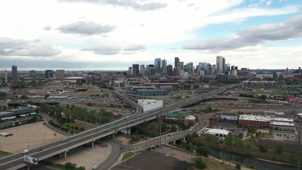 Vista aérea del tráfico en la autopista a las afueras del centro de Denver, Colorado, EE. UU., bajo un cielo dramático, toma de dron.