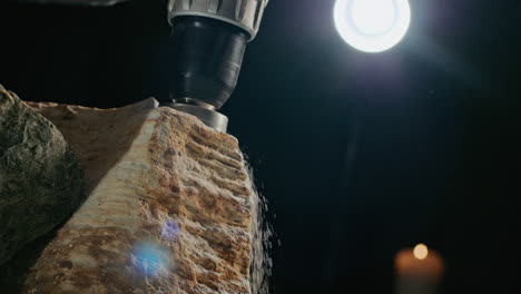 close-up of a craftsman carving stone with a power drill