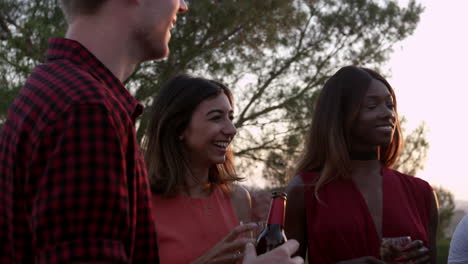 adult friends socialising at a party on a rooftop at sunset, shot on r3d