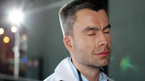 close up of caucasian physician taking off medical mask and goggles and looking at camera