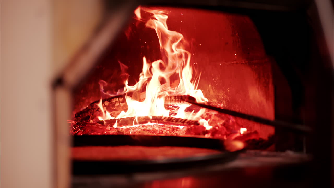 Man throwing wood in a burning fireplace