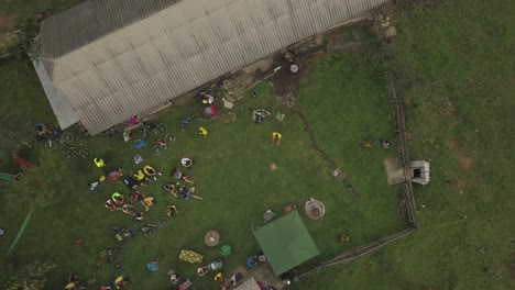 Aerial-top-view-of-bikers-resting-during-Tura-Cu-Copaci,-a-bicycle-race-in-Colibita-Lake,-Romania