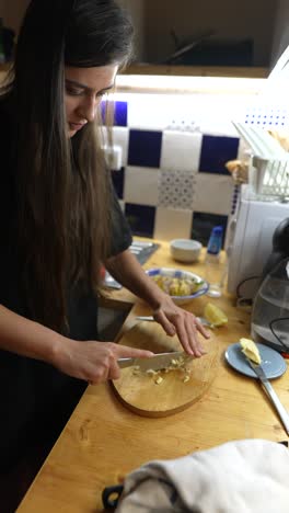 mujer cortando ajo en la cocina