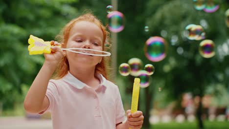 little girl blowing bubbles in a park