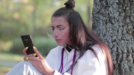 Beautiful-girl-in-a-park-watching-something-surprising-on-her-phone