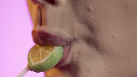 woman-licking-popsicle-with-her-tongue,-mouth-close-up-shot-on-pink-background