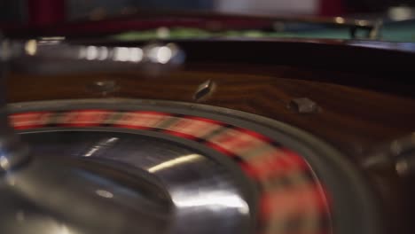 a spinning roulette wheel in a casino with the ball just dropped down and bouncing out of the wheel making the round invalid