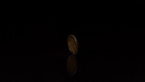 una moneda de dos euros que gira sobre un fondo negro