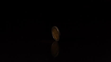 two euro coin spinning on black background