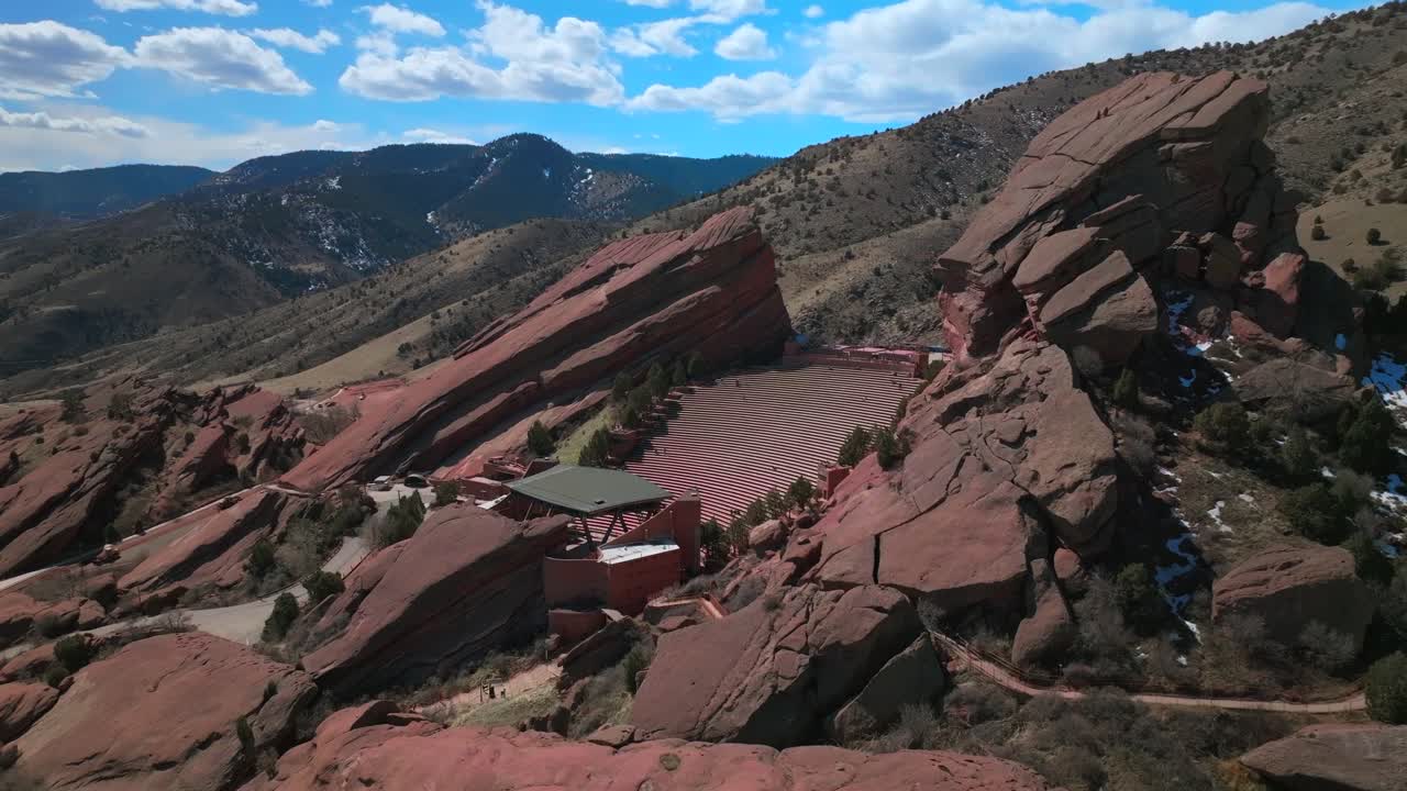 Red Rocks Park and Amphitheater Mount Morrison Colorado aerial drone mid winter windy roads walking trails Trading Post sunny blue sky clouds full parking lot cars stairs tourist area forward pan up