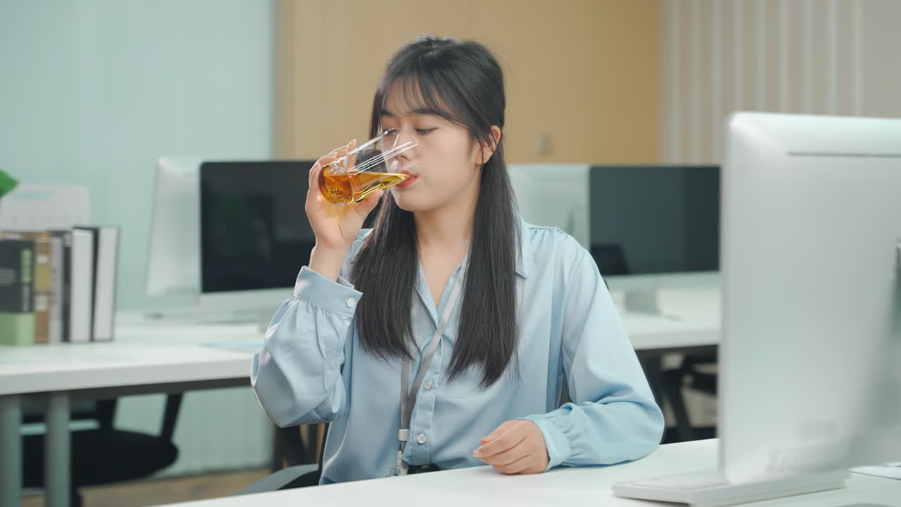 นักธุรกิจหญิงที่เหนื่อยล้าและเคร่งเครียด กำลังจิบชาอุ่นๆ ในสำนักงานพร้อมคอมพิวเตอร์แล็ปท็อป เธอผิดหวังและครุ่นคิดอย่างหนักจากการทำงานล่วงเวลา ทำงานหนักเกินไป ทำงานหลายอย่างพร้อมกัน และกำหนดเส้นตายที่ยากลำบาก