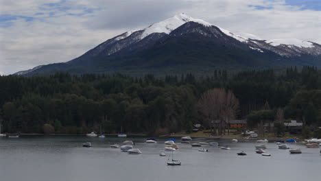 movimiento de drones laterales cerca de la villa la orilla del lago angostura con pico y montaña nevada, argentina.