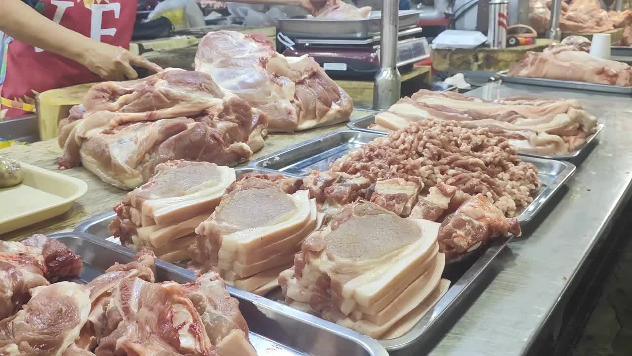 Pork in a wet market is often displayed in a variety of cuts, fresh and vibrant, with gleaming pink flesh. I