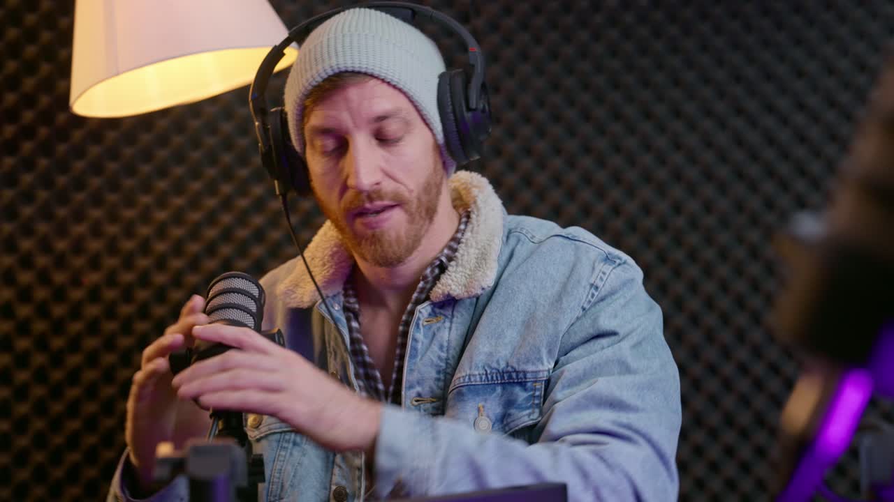 podcaster terminando un programa, despidiéndose de la audiencia mientras se relaja en su silla. quita los auriculares, cierra la consola y concluye la sesión en una configuración de estudio profesional