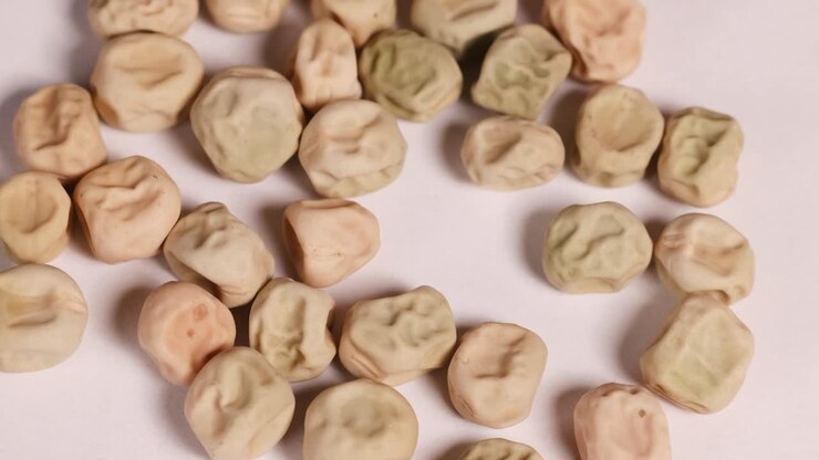 Beans move subtly with a toothpick on a flat surface, demonstrating a simple science experiment with natural lighting