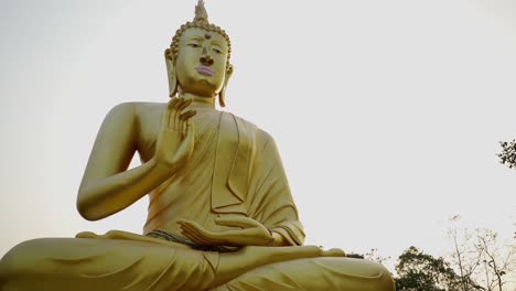 majestic golden buddha statue against a serene sky