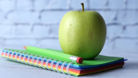 manzana verde en un cuaderno en espiral de colores