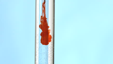 jeringa que inyecta sangre en un tubo de ensayo de agua