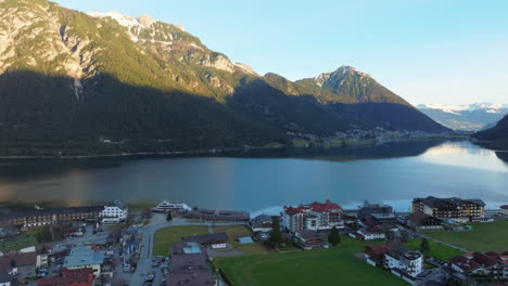 montañas escénicas y pueblo a orillas del lago achensee en tirol, austria - toma aérea de drones