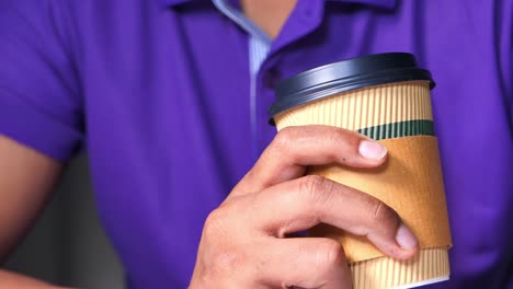 person holding a paper cup of coffee