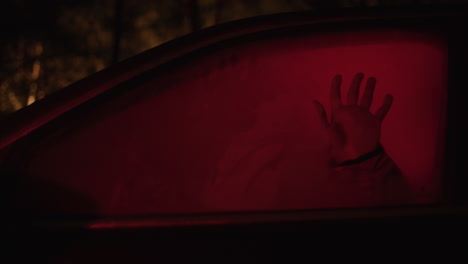 mysterious silhouette in a car window at night
