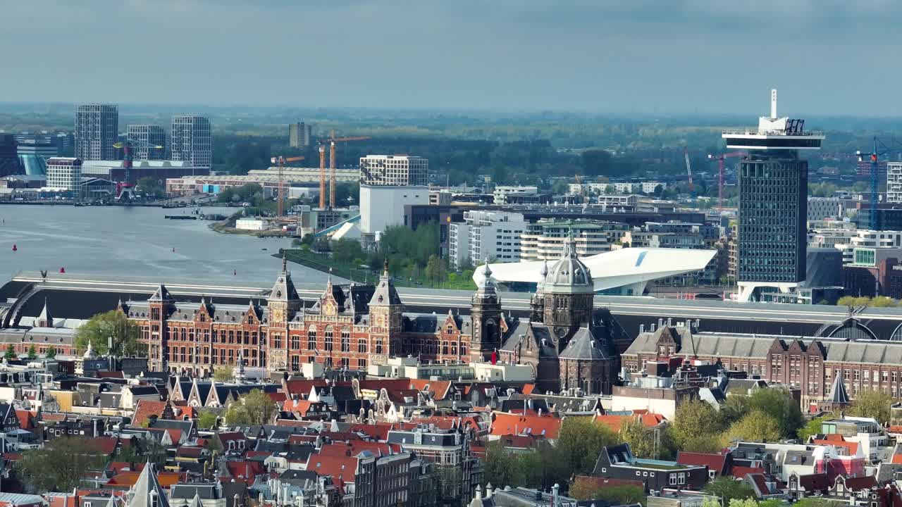 드론은 암스테르담의 센트럴 스테이션을 텔레포토 렌즈로 바라보며 으로 날고 있습니다.