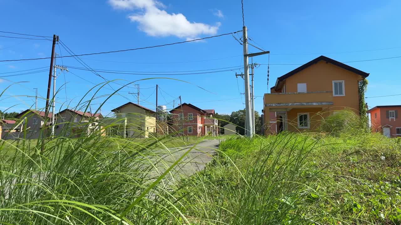 フィリピン、カビテ州アルフォンソのカメリア・ホームズにある郊外の村の、整理された住宅配置を示す地上からの側面視点。