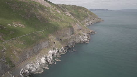 railway tracks on the cliffs passing through the tunnel at bray head mountain in wicklow, ireland