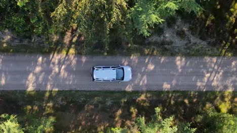 Weißes-Auto,-Das-Durch-Die-Natur-Fährt,-Drohnenaufnahmen