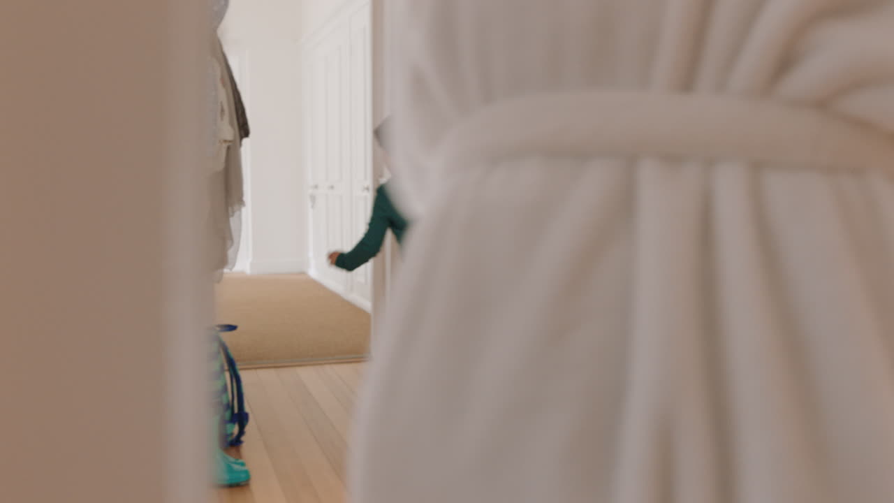 행복한 아시아 어머니가 작은 소년과 함께 캐치 게임을 하며 집을 달리는 어머니는 아들을  ⁇ 고 함께 즐거운 주말을 즐기고 있습니다. 4k 영상