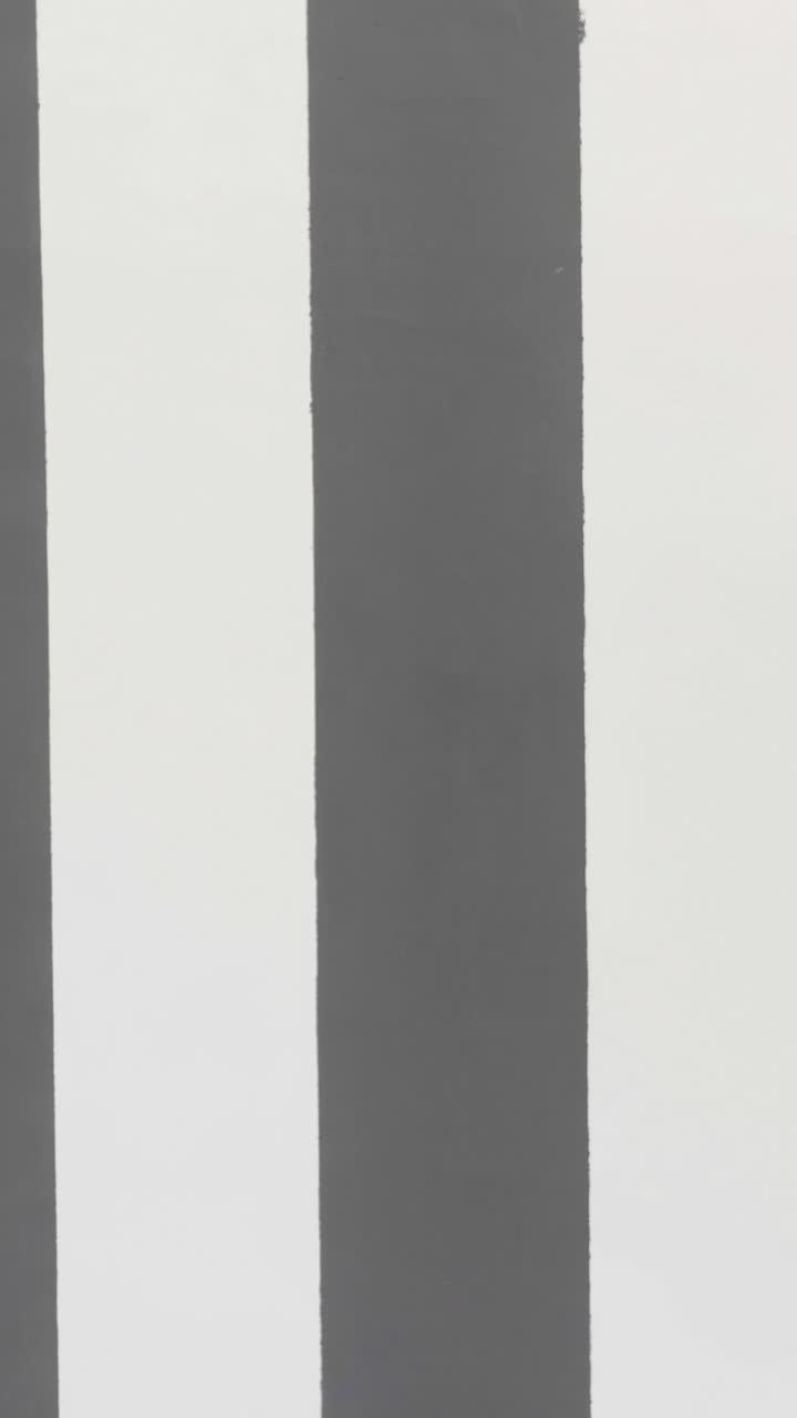 Man walking past striped wall