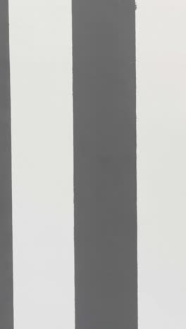 man walking past striped wall