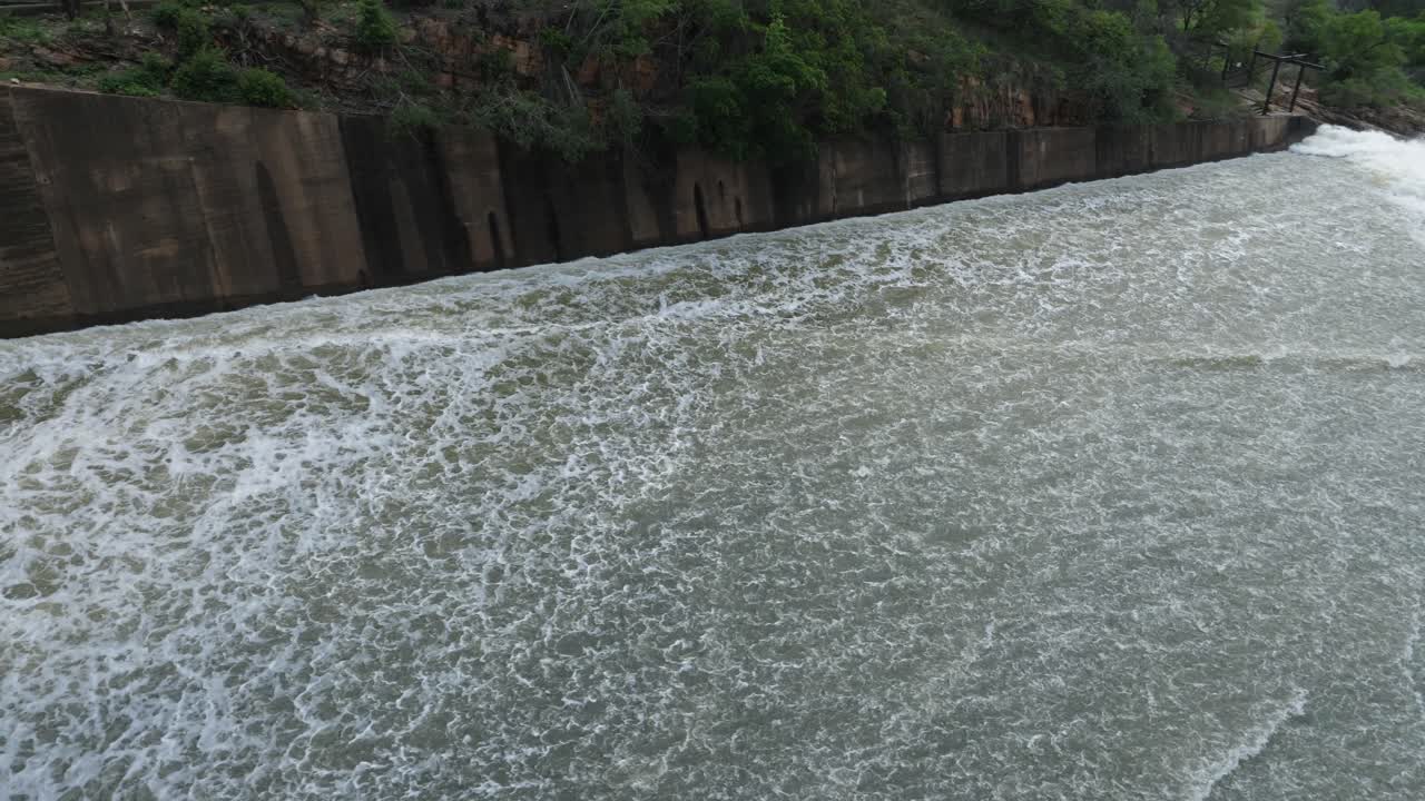pan sigue el agua que corre por el aliviadero de la represa hidroeléctrica hasta la cascada debajo