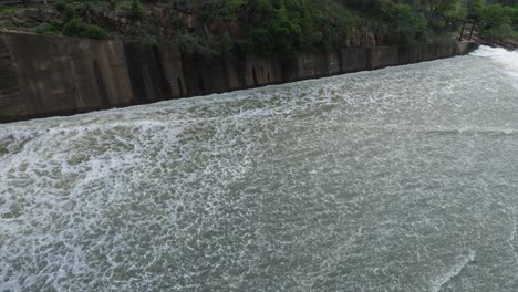 pan follows water rushing down hydro dam spillway to waterfall below