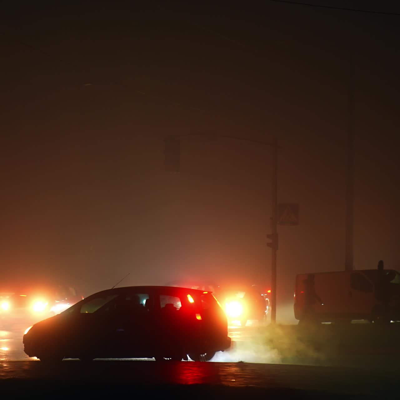 Complicated traffic in the streets of city in blackout time. Car lights are the only source of light on the roads