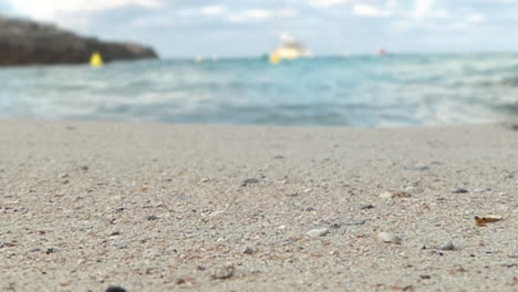 vista de cerca de arena dorada y pequeñas olas de mar borrosas aplastando en la orilla de la playa