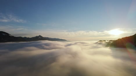 drone shot of an incredible landscape covered under the fog with surrounding mountains in the morning at winter time in slovenia captured in 4k, drone going right to left