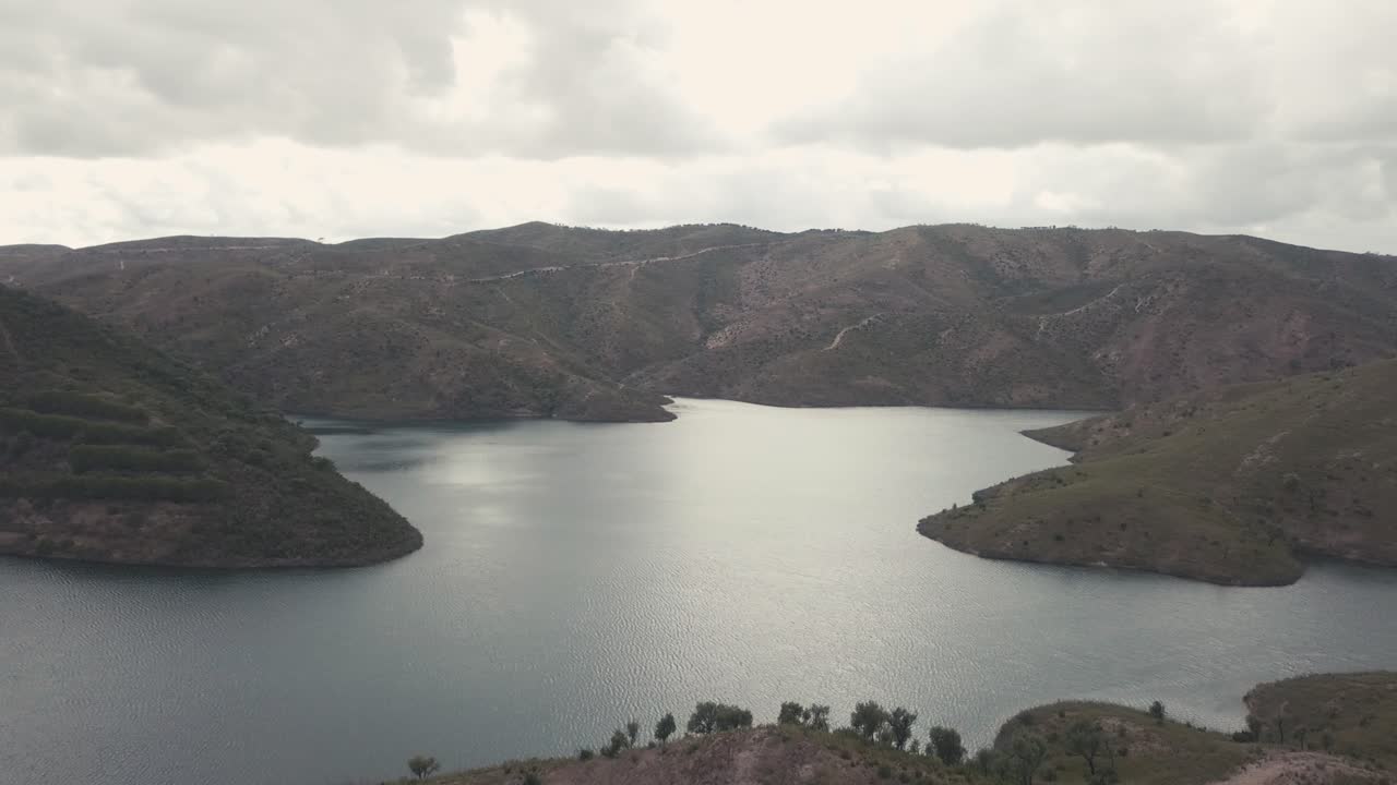tranquilo lago azul rodeado de montañas rocosas después del atardecer en portugal