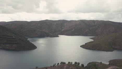 Tranquil-blue-lake-surrounded-by-rocky-mountains-after-sunset-in-Portugal