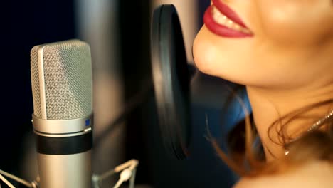 young woman recording a song in a professional studio.