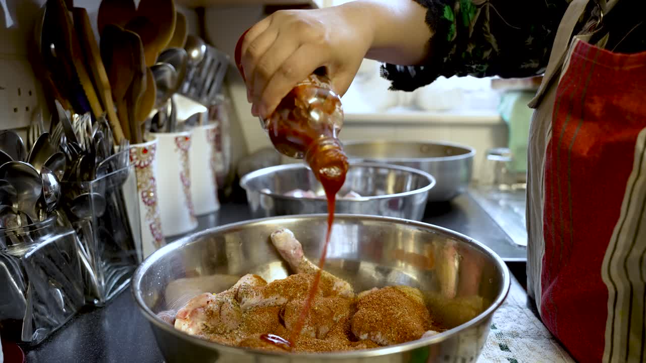 An individual tenderizes chicken pieces with sauce, capturing the essence of culinary preparation and food craftsmanship