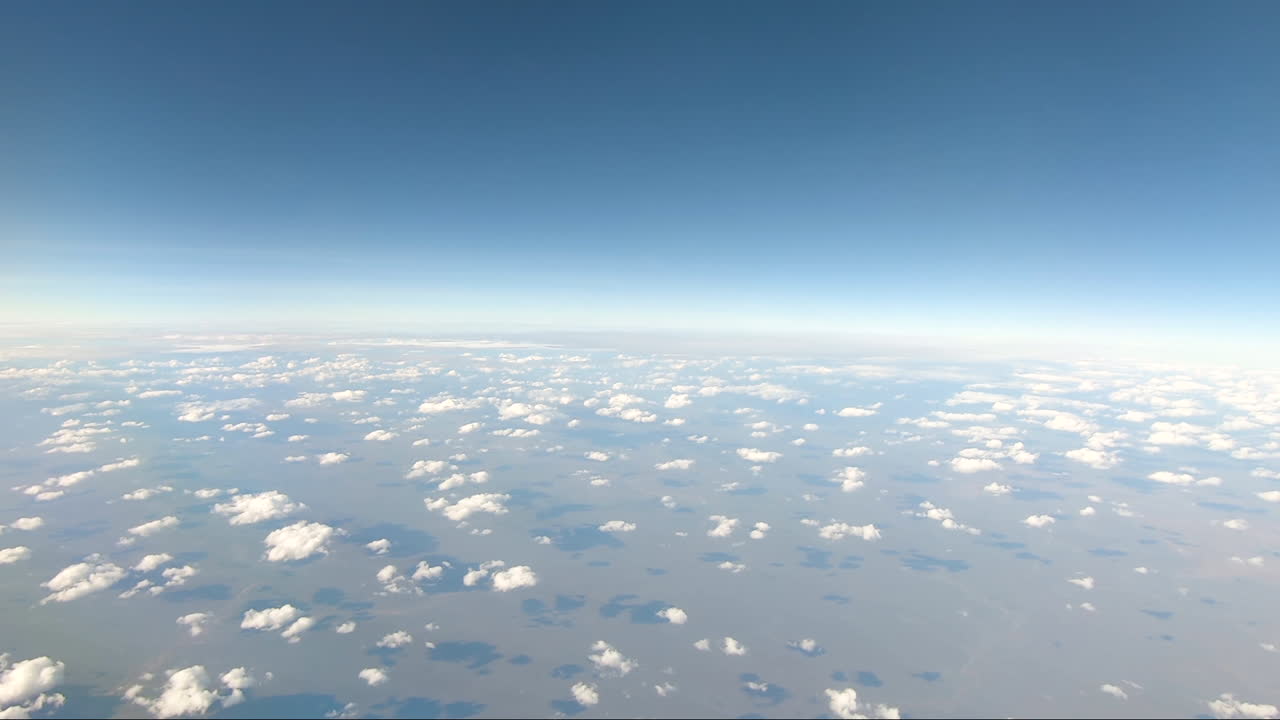 다윈 노던 테리토리(darwin northern territory)에서 비행하는 항공기 창의 pov는 구부러진 수평선 흰 구름이 붉은 지구 아웃백 호주에 그림자를 드리우는 것을 보여줍니다.