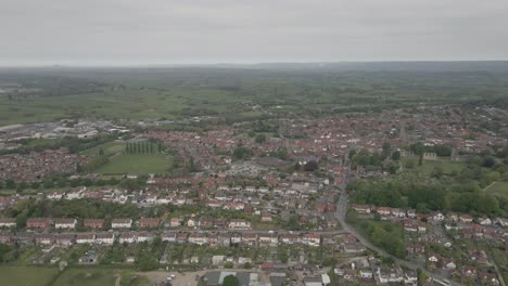 aerial view of glastonbury town, drone moving to the right over the houses showing all extension of glastonbury. green fields and around the town . 4k,
