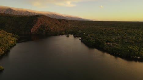 Aerial-flyover-peaceful-lake-during-sunset-time-with-tremendous-mountain-range-in-background---South-America,Argentina