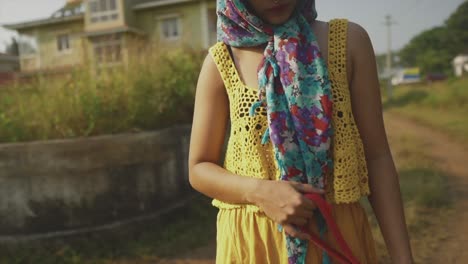 Chica-De-Moda-Con-Colorido-Vestido-Amarillo-Con-Pañuelo-En-La-Cabeza-Y-Correa-De-Perro-Roja-Al-Aire-Libre