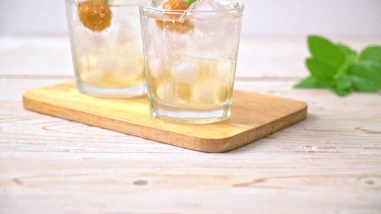 Jugo de ciruela helado con soda y menta en la mesa de madera - bebida refrescante