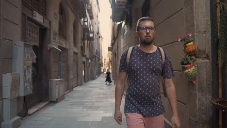 man walking down a narrow city alley in barcelona