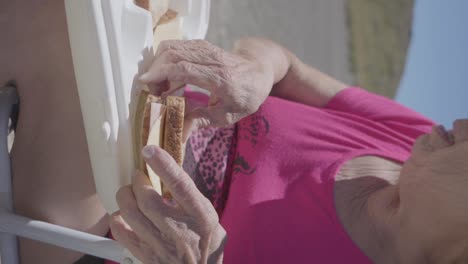 una mujer madura haciendo un bocadillo de jamón y queso